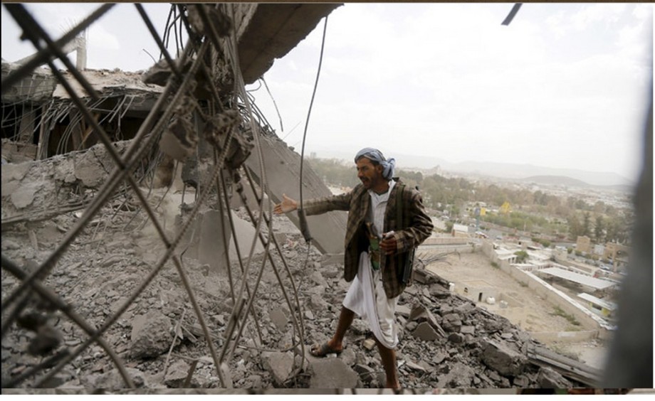 man inspects the damaged building caused by Saudi air strike in Sanaa 08 April 2015